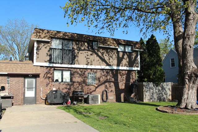 view of front of house featuring brick siding, cooling unit, and a patio