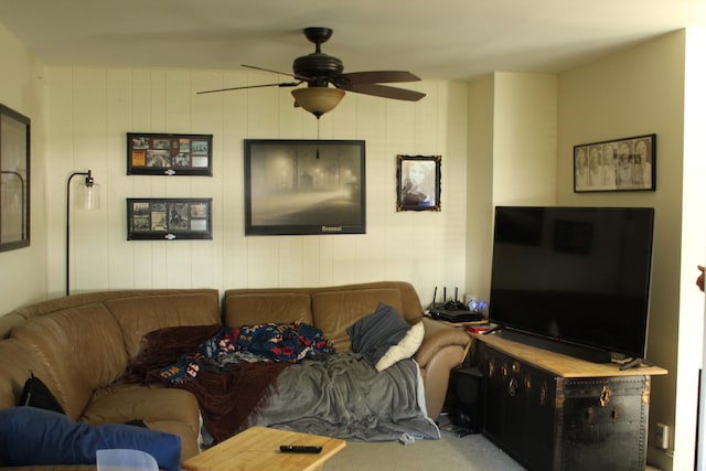 living area featuring ceiling fan and carpet