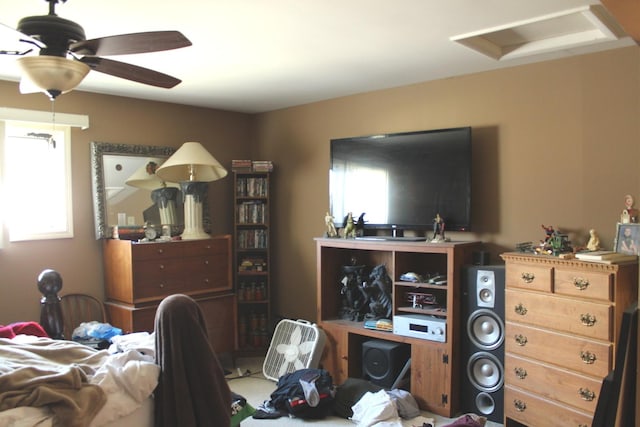 bedroom featuring multiple windows, attic access, and a ceiling fan