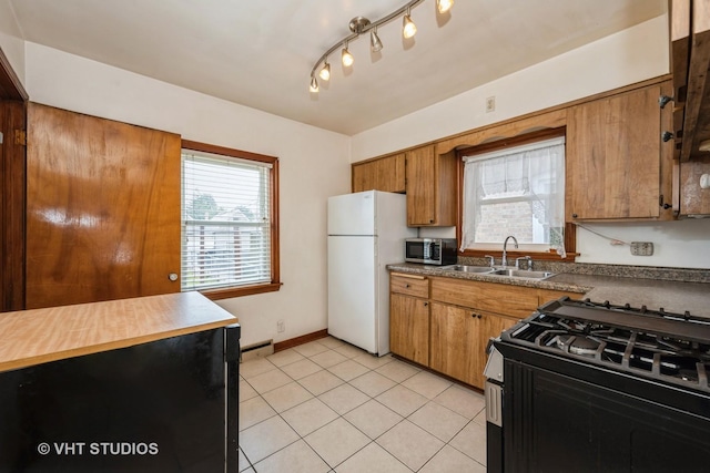 6119 S Melvina Ave, Chicago, IL 60638 - kitchen with freestanding refrigerator, range with gas cooktop, stainless steel microwave, brown cabinets, and baseboard heating