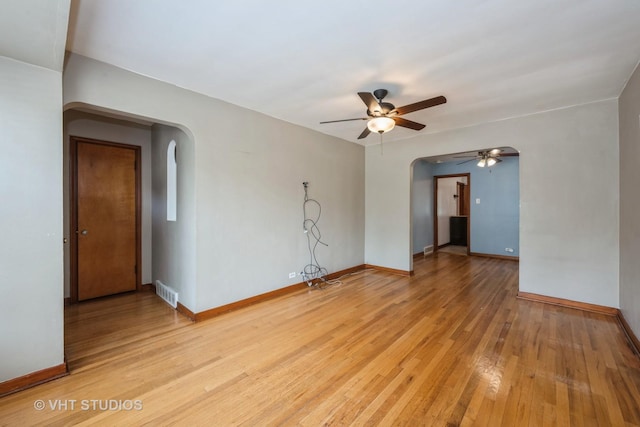 6119 S Melvina Ave, Chicago, IL 60638 - spare room with arched walkways, a ceiling fan, and light wood-style flooring