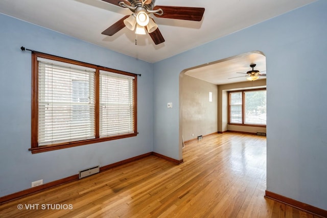 6119 S Melvina Ave, Chicago, IL 60638 - unfurnished room featuring a ceiling fan, arched walkways, and light wood-style floors