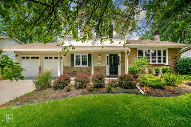 902 E Plate Dr, Palatine, IL 60074 - view of front facade featuring brick siding, driveway, an attached garage, and a front yard