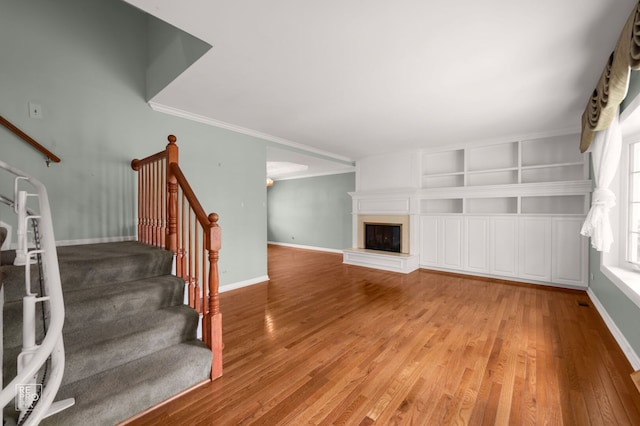 902 E Plate Dr, Palatine, IL 60074 - unfurnished living room featuring stairs, light wood-type flooring, a large fireplace, and crown molding