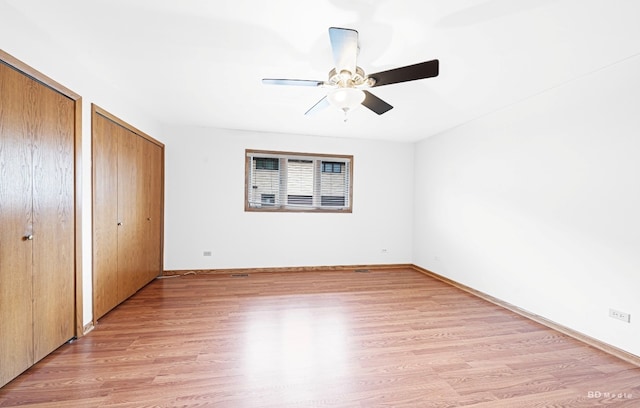 16052 Eagle Ridge Dr, Tinley Park, IL 60477 - unfurnished bedroom with multiple closets, light wood-type flooring, baseboards, and a ceiling fan