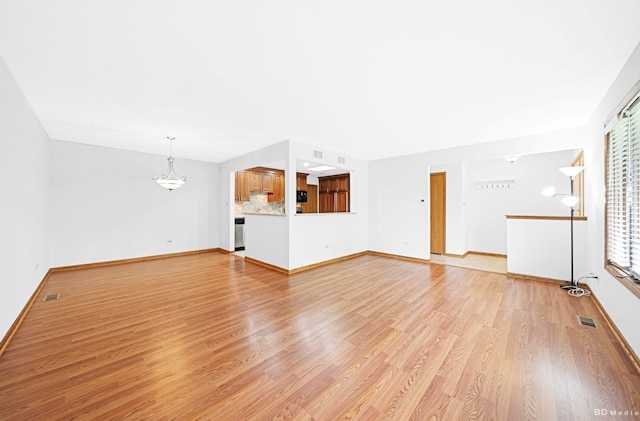 16052 Eagle Ridge Dr, Tinley Park, IL 60477 - unfurnished living room featuring light wood finished floors, a chandelier, and baseboards