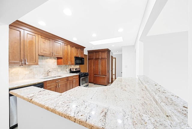 16052 Eagle Ridge Dr, Tinley Park, IL 60477 - kitchen featuring stainless steel gas range, black microwave, a sink, a skylight, and light stone countertops