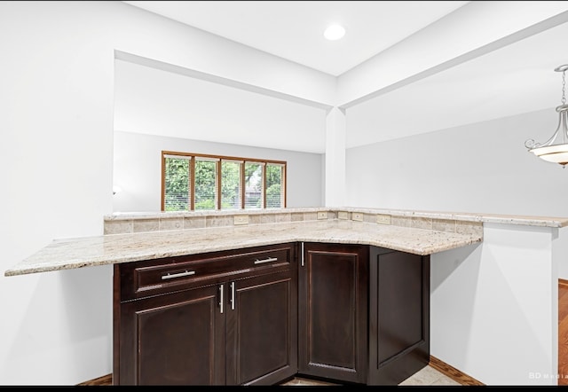 16052 Eagle Ridge Dr, Tinley Park, IL 60477 - kitchen featuring dark brown cabinetry, light stone countertops, decorative light fixtures, recessed lighting, and a peninsula