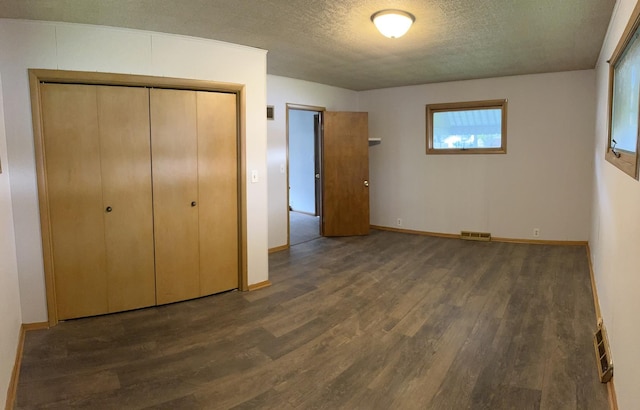 1112 1st Ave, Ottawa, IL 61350 - unfurnished bedroom featuring wood finished floors, a closet, baseboards, and a textured ceiling