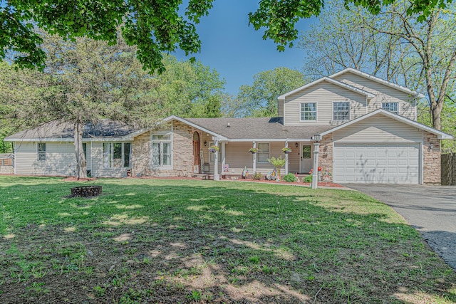 25647 W Old Grand Ave, Ingleside, IL 60041 - view of front of house featuring driveway, covered porch, a front yard, a garage, and stone siding