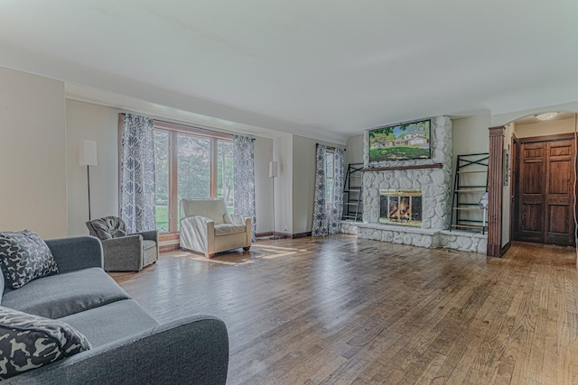 25647 W Old Grand Ave, Ingleside, IL 60041 - living room featuring wood finished floors, a fireplace, arched walkways, baseboards, and ornate columns
