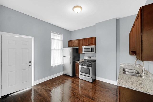7223 S Union Ave, Chicago, IL 60621 - kitchen with stainless steel appliances, a sink, baseboards, dark wood finished floors, and light stone countertops