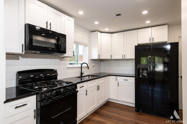 kitchen featuring black appliances, a sink, dark countertops, recessed lighting, and white cabinetry
