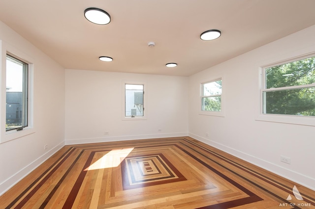 spare room with plenty of natural light and baseboards