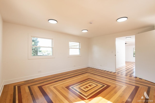empty room with baseboards, plenty of natural light, and a smoke detector