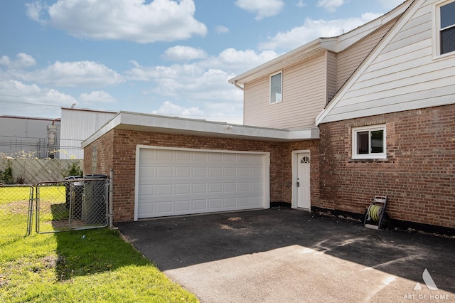 view of front of home featuring asphalt driveway, fence, brick siding, a garage, and central AC