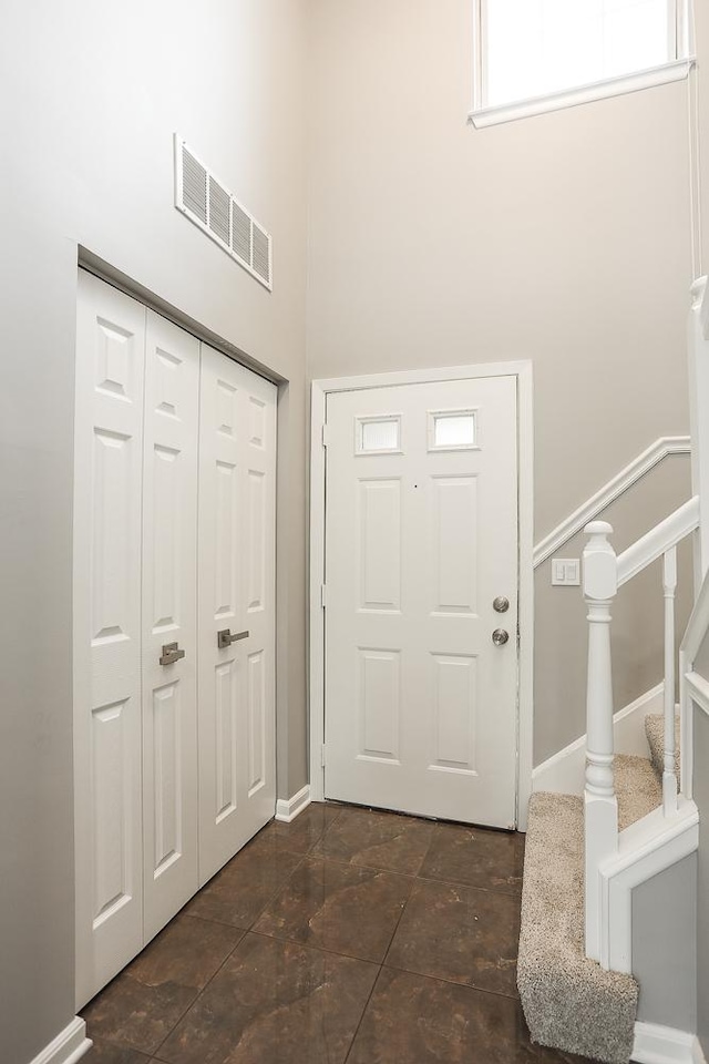 entrance foyer featuring stairway and baseboards