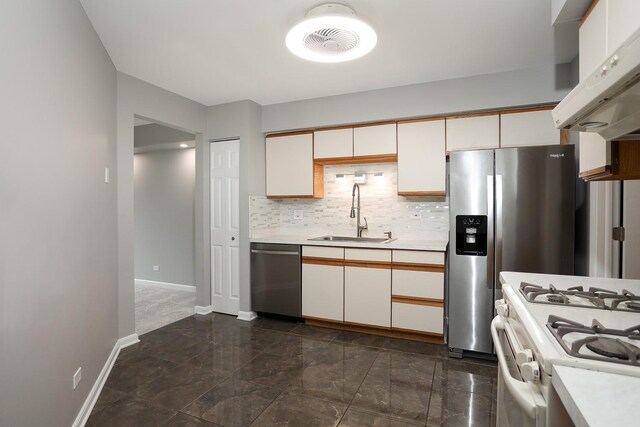 kitchen with stainless steel appliances, a sink, under cabinet range hood, and light countertops