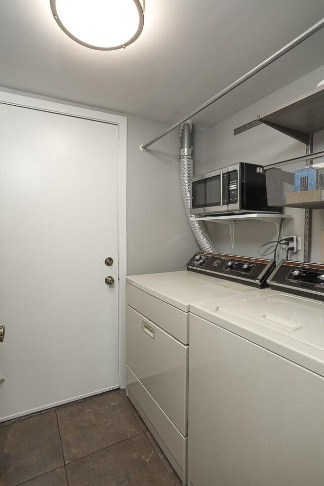 clothes washing area featuring independent washer and dryer and dark tile patterned floors
