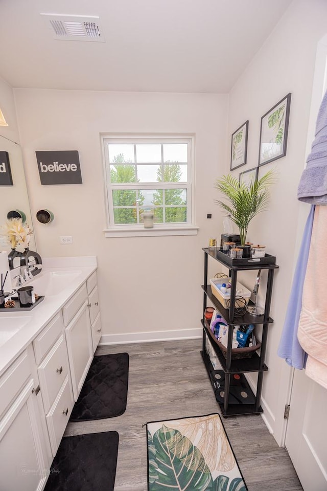 full bathroom with wood finished floors, double vanity, and baseboards