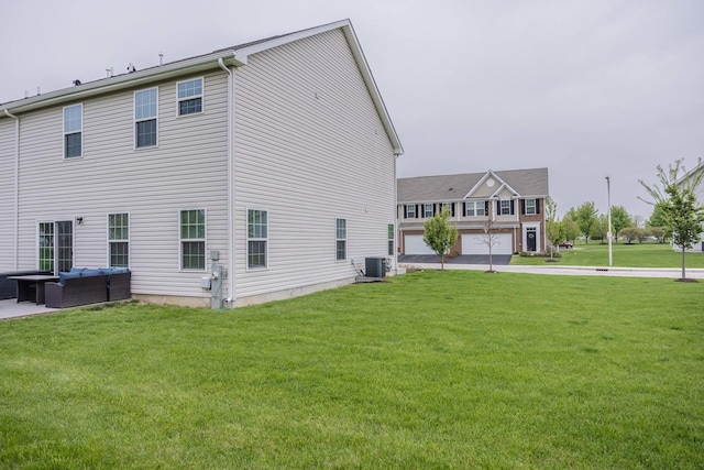 rear view of house featuring central AC unit, an outdoor living space, and a yard