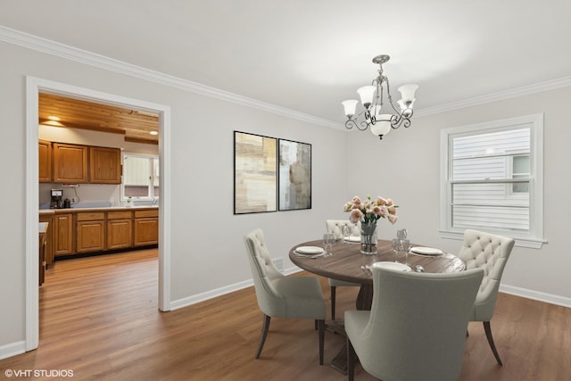 206 Villa Ave, Lake Villa, IL 60046 - dining area featuring a chandelier, crown molding, baseboards, and light wood-type flooring
