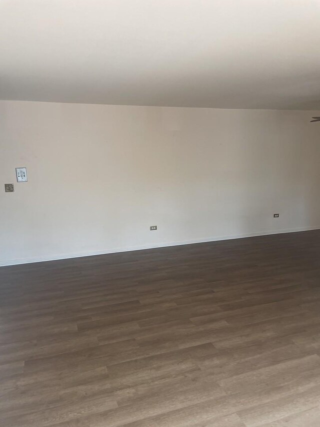 spare room with wood finished floors and baseboards