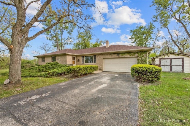 ranch-style home with a garage, driveway, a chimney, a front lawn, and brick siding