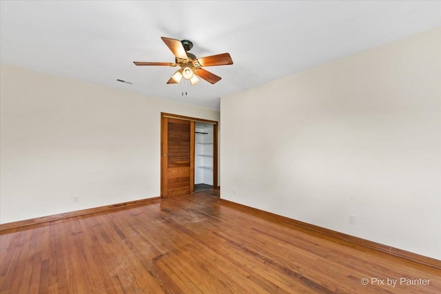 unfurnished room with baseboards, a ceiling fan, and wood finished floors