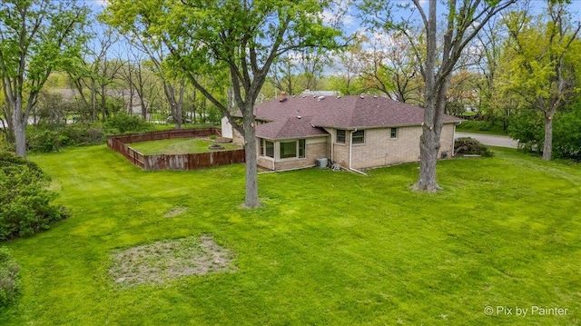 back of property with brick siding and view of wooded area