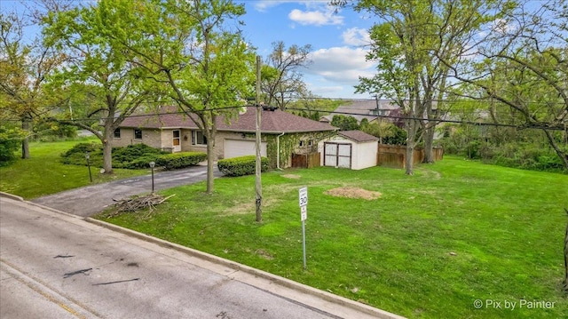 ranch-style house with a storage shed, an attached garage, an outbuilding, and asphalt driveway