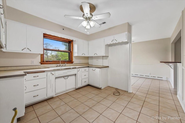 kitchen featuring a sink, a baseboard heating unit, a ceiling fan, white cabinets, and light countertops
