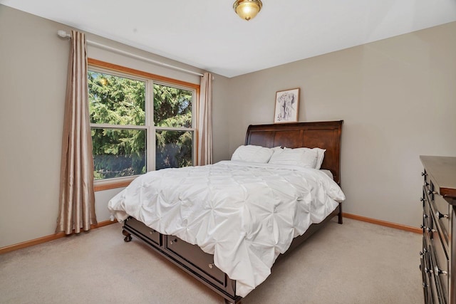 bedroom featuring light colored carpet and baseboards