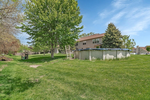 view of green lawn with a covered pool