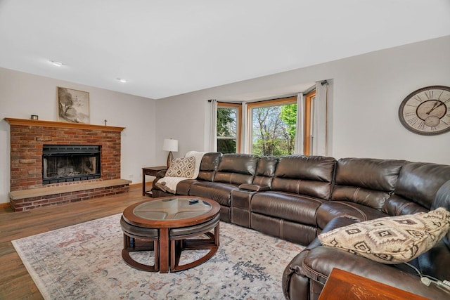 living room with wood finished floors, a fireplace, baseboards, and recessed lighting