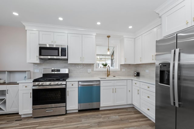 kitchen with stainless steel appliances, a sink, white cabinets, light countertops, and recessed lighting