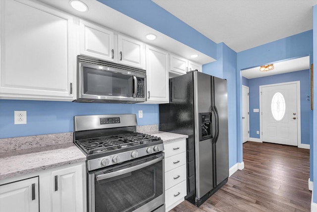 19 Nightingale Cir, Camargo, IL 61919 - kitchen with appliances with stainless steel finishes, baseboards, white cabinets, dark wood-style flooring, and light stone counters