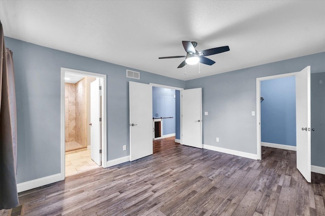 19 Nightingale Cir, Camargo, IL 61919 - unfurnished bedroom featuring wood finished floors, baseboards, a spacious closet, ceiling fan, and connected bathroom