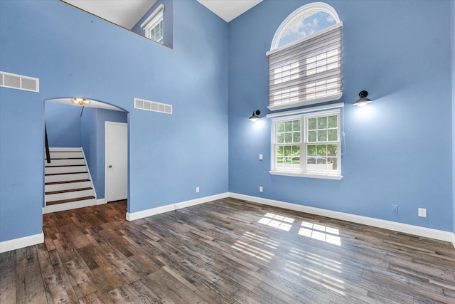 19 Nightingale Cir, Camargo, IL 61919 - unfurnished room featuring a high ceiling, stairway, baseboards, wood finished floors, and arched walkways