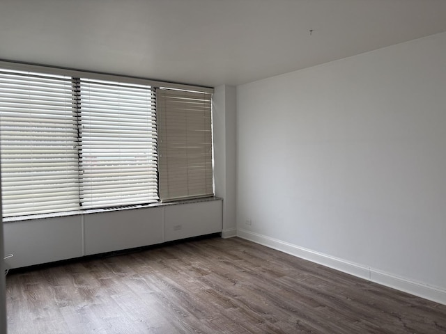 unfurnished room featuring wood finished floors and baseboards