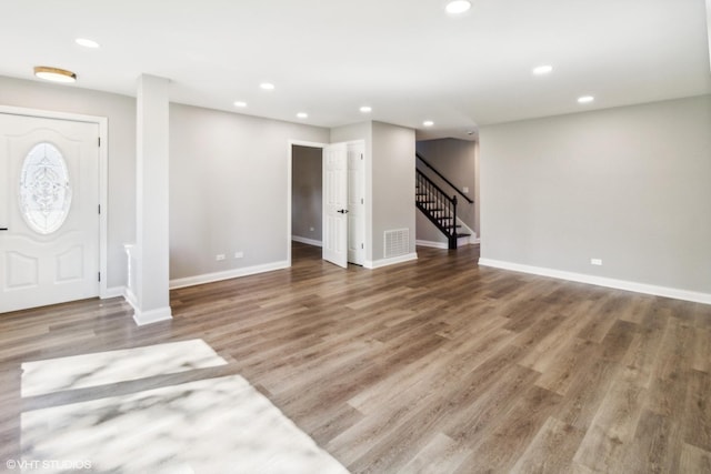 entryway with stairway, baseboards, wood finished floors, and recessed lighting