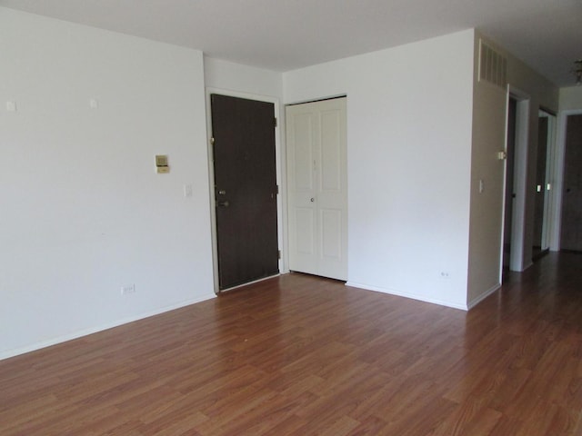 spare room with wood finished floors and baseboards