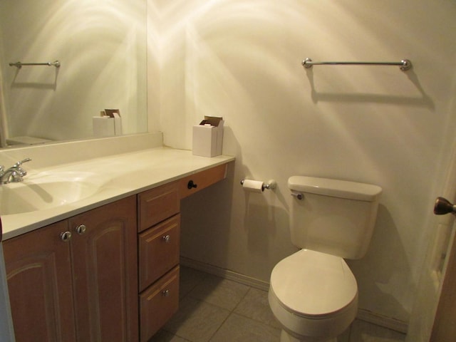 bathroom with toilet, tile patterned flooring, vanity, and baseboards