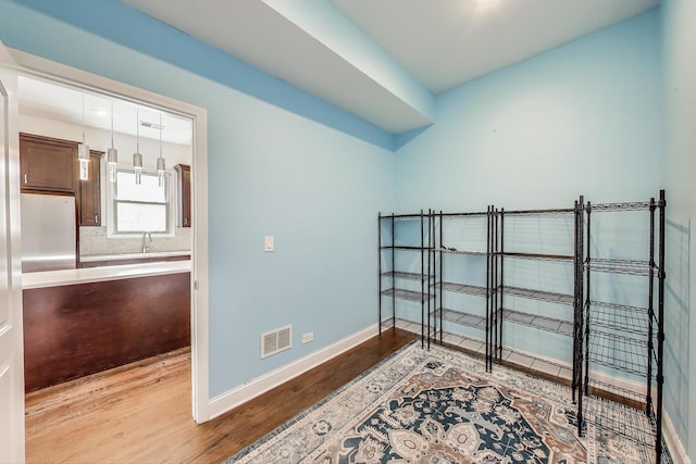 4723 W Shakespeare Ave, Chicago, IL 60639 - spare room featuring wood finished floors, baseboards, and a sink