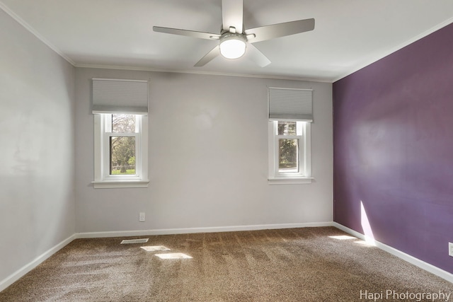 carpeted empty room featuring plenty of natural light, crown molding, a ceiling fan, and baseboards