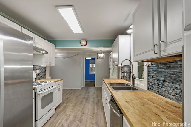 kitchen with butcher block counters, appliances with stainless steel finishes, and a sink
