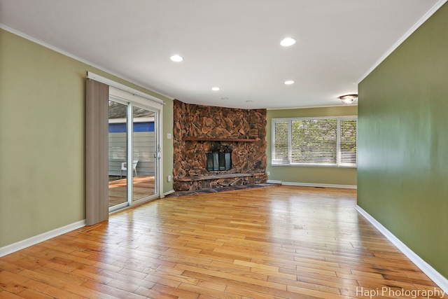 unfurnished living room with ornamental molding, baseboards, hardwood / wood-style floors, a fireplace, and recessed lighting