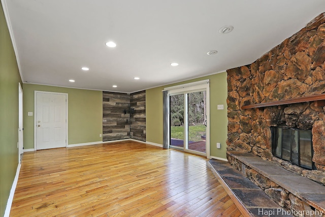 unfurnished living room with a fireplace, baseboards, crown molding, hardwood / wood-style flooring, and recessed lighting