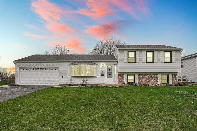 1324 Elmhurst Ln, Schaumburg, IL 60194 - tri-level home featuring a garage, driveway, and a front yard