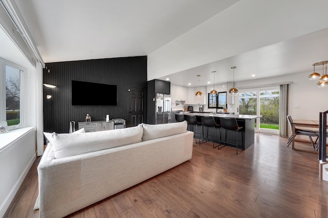 1324 Elmhurst Ln, Schaumburg, IL 60194 - living area featuring an accent wall, lofted ceiling, wood finished floors, baseboards, and recessed lighting